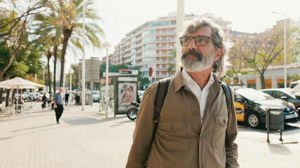 Middle-aged man walking down the street with backpack © Andrii Nekrasov