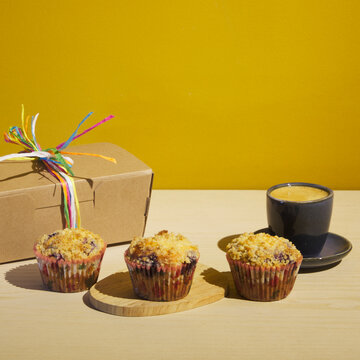 Muffins with a cofee/chocolate and a packaging box. Perfect for bakery advertising and ambience