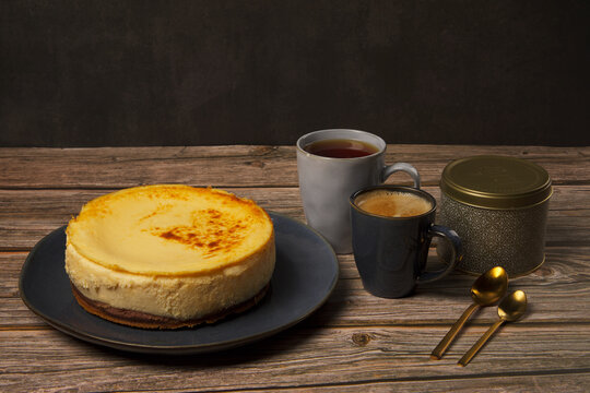 Cheesecake with mugs of coffee, tea and chocolate