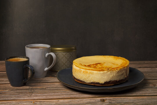 Cheesecake with mugs of coffee, tea and chocolate