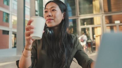 Young woman freelancer working on laptop and drinking coffee