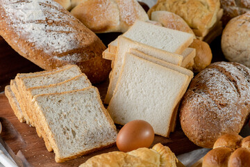 Mix bread kind of cereal bakery yeast white bread, pasties, buns, rye pretzel sourdough leavened tortilla and croissant on old wooden background.