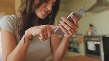 Close-up of girl's hands scrolling through photos and videos on her smartphone