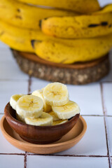 banana madura fatiada com penca de bananas ao fundo. foco seletivo