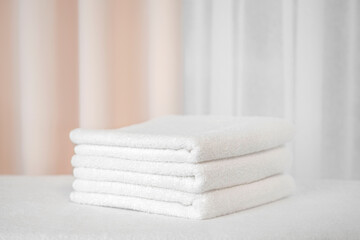 Fototapeta na wymiar Three white terry bath towels on a light background