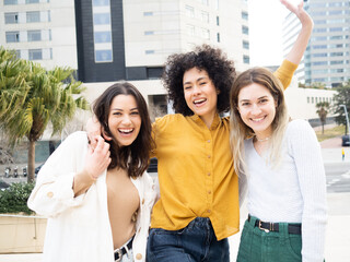 Three young women best friends having fun looking at camera . Unity and friendship concept