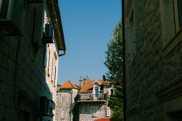Fototapeta na wymiar Narrow Perast street with old stone houses with red tiled roofs