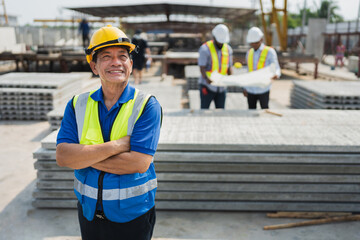 Portrait Asia senior engineer man cross arm with team working with paper work and precast cement factory background