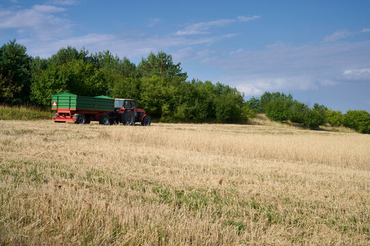 Tractor with trailer in grain field