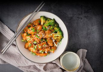 Chopsticks with Delicious sweet chopping chicken rice, sesame seeds, sliced spring onions, broccoli, and vegetables. Asian food, Japanese food. To view
