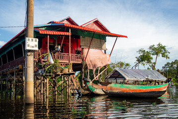 Fototapeta na wymiar Floating Village on the water of a river in Thailand, colorful reflection on the water, pier and houses