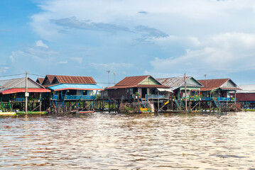 Floating Village on the water of a river in Thailand, colorful reflection on the water, pier and houses