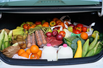 close up on fresh food from grocery store in car trunk