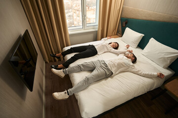 Newlyweds are resting on the bed after the flight