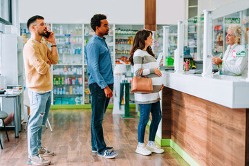 Customers in busy pharmacy.