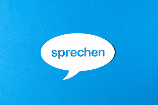 Deutsches Wort sprechen in einer Sprechblase aus Papier ausgestanzt vor blauem Hintergrund. Fotorealistischer Vektor.