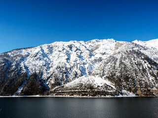 Achensee in der Gemeinde Eben am Achensee in Tirol. Blick vom Pertisauer Ufer. Sein ruhiges Wasser am Fuße der schneebedeckten Berge
