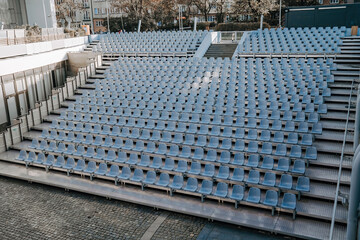 Field of empty plastic blue chairs seats on stadium.