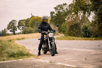 motorcyclist on a motorcycle in the spring in a helmet, retro cafe racer.