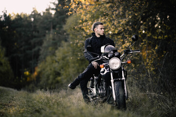 Fototapeta na wymiar man with a motorcycle in the outfit in the spring the beginning of the motorcycle season.