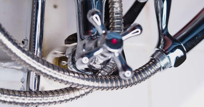 Repair of a leaky faucet. Close-up of an adjustable wrench tightening a nut with a gasket to stop water leaking.