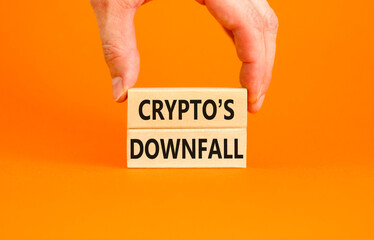 Crypto downfall symbol. Concept words Cryptos downfall on wooden blocks. Beautiful orange table orange background. Businessman hand. Business and crypto downfall concept. Copy space.