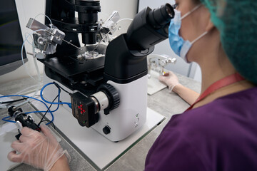 Medical worker examines blood samples on a powerful microscope