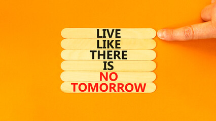 Live like no tomorrow symbol. Concept words Live like there is no tomorrow on wooden stick. Beautiful orange background. Businessman hand. Business Live like no tomorrow concept. Copy space.