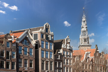 Old Church tower - Oude Kerk, and facades of old historic canal houses in the center of Amsterdam.