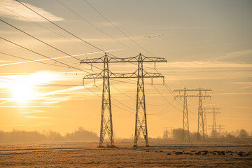 Silhouette of electrical tower during a tranquil sunries in the countryside.