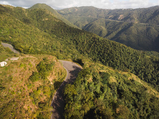 Rural curved road drone shot in the green mountains from puerto rico	
