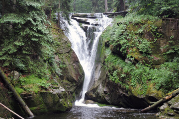 Szklarka Waterfall, the waterfall in the Polish part of The Karkonosze Mountains falling from a rocky wall in the forest