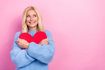 Photo of dreamy cute positive lady hand hold red paper card interested look empty space isolated on pink color background