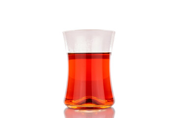 One glass of black aromatic tea, macro, isolated on white background.