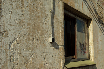 Window in old building. Industrial zone. Paint-free wall.