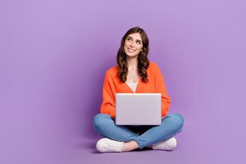 Naklejka premium Full length photo of thoughtful dreamy lady wear orange cardigan looking empty typing sms device isolated violet color background