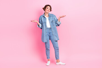 Full length photo of charming unconfident woman wear jeans shirt shrugging shoulders isolated pink color background