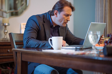 Hombre de negocios revisando atentamente su computadora personal.