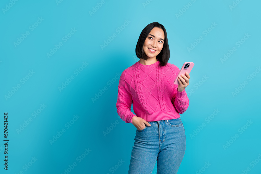 Wall mural photo of pretty malaysian girl hold telephone look empty space promo isolated on blue color backgrou