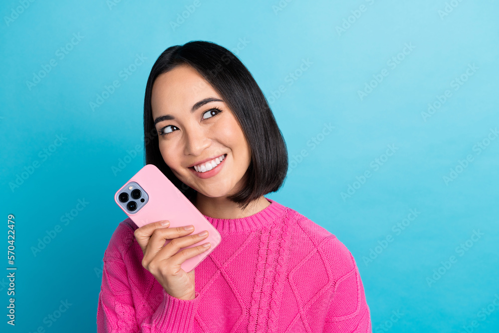 Sticker Photo of lovely positive filipino person hold telephone beaming smile look empty space isolated on blue color background