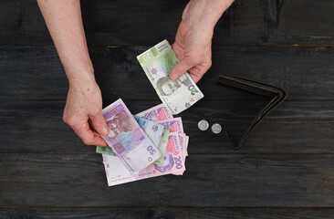 An elderly pensioner is counting her meager cash savings.