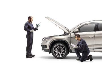 Mechanics checking a suv and cleaning a dipstick for oil check - Powered by Adobe