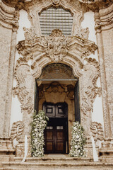 Fototapeta na wymiar L'entrée de l'église décorée de fleurs pour la célébration de mariage
