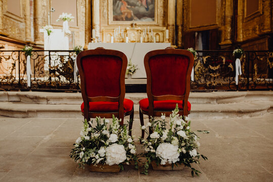Les chaises des futurs époux décorés de bouquets de fleurs