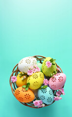 Multi colors Easter eggs in the basket and flowers on blue background. Pastel color Easter eggs.