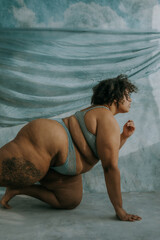 portrait of a plus size afro indigenous person on knees looking towards sun
 - obrazy, fototapety, plakaty