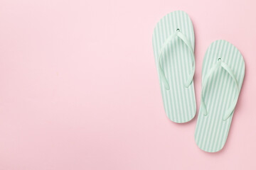 Striped flip flops on color background, top view