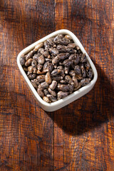 Castor grains and oil on the table, close-up image