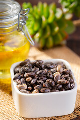 Castor grains and oil on the table, close-up image