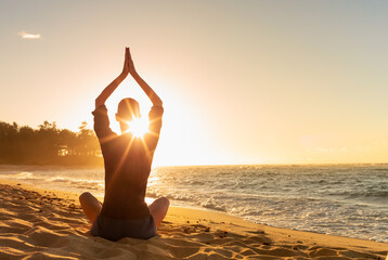 Female practicing meditation on the beach. Mind health body spirit concept. 